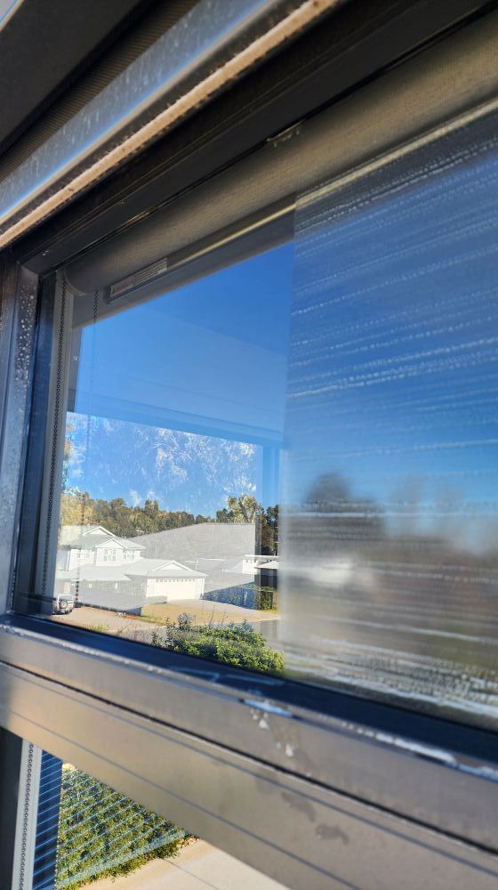 Window View Showing a Clear Sky and Blurry Buildings — Rapid Rinse Solutions in Katunga, VIC