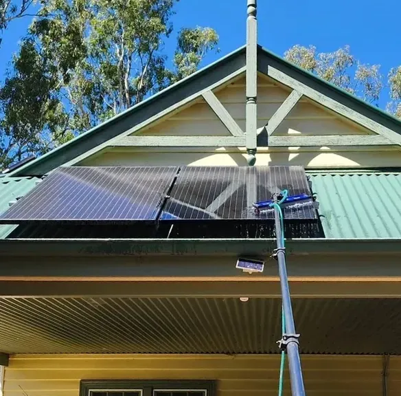 Person Cleaning Solar Panels on a Green Roof — Rapid Rinse Solutions in Cobram, VIC