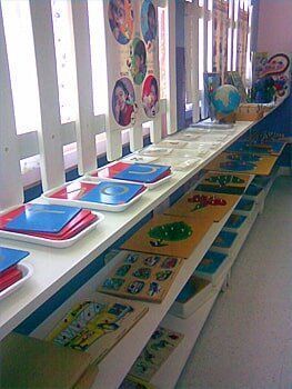 A long shelf filled with lots of toys and a globe.