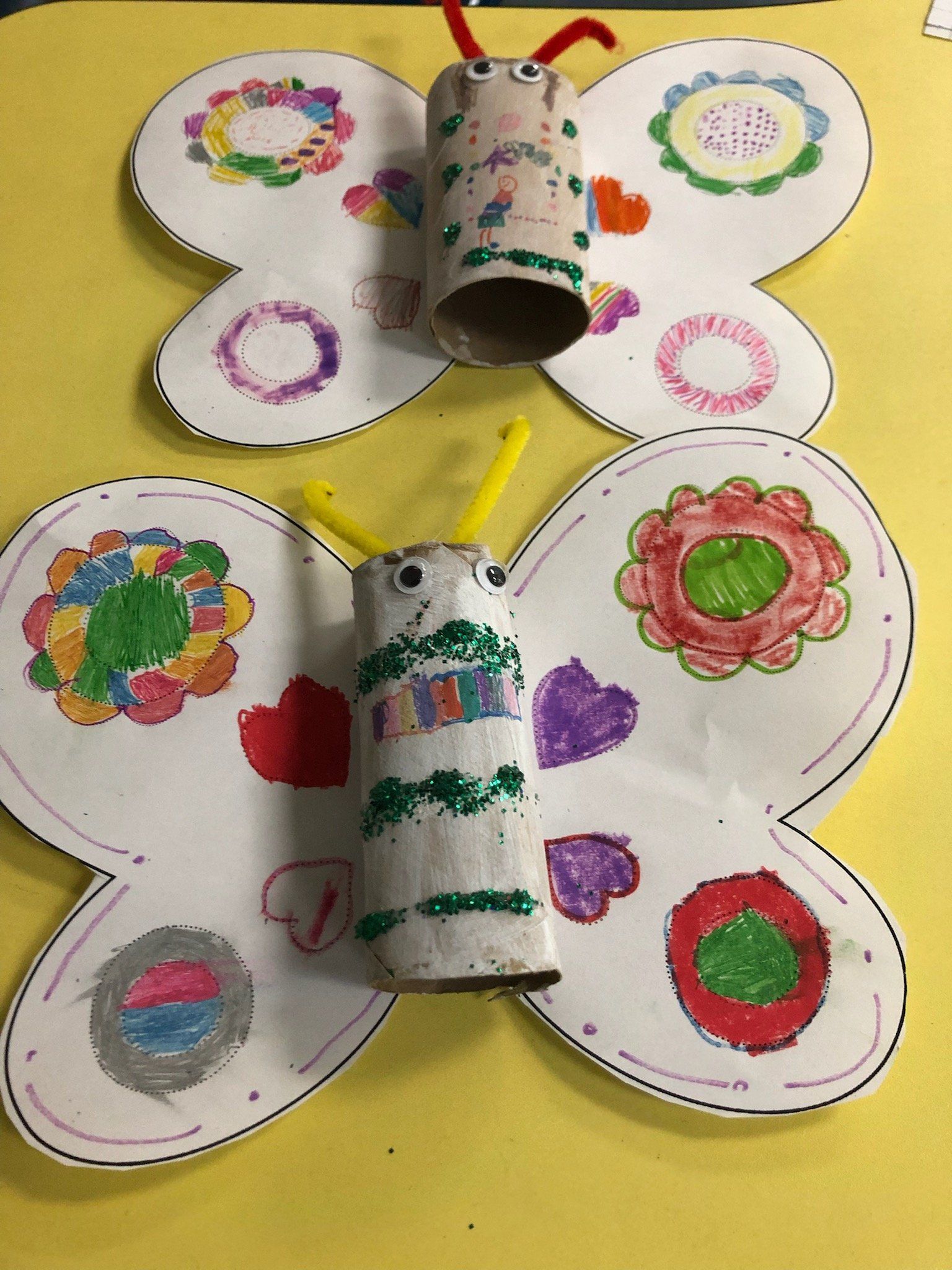 A butterfly made out of toilet paper rolls and flowers