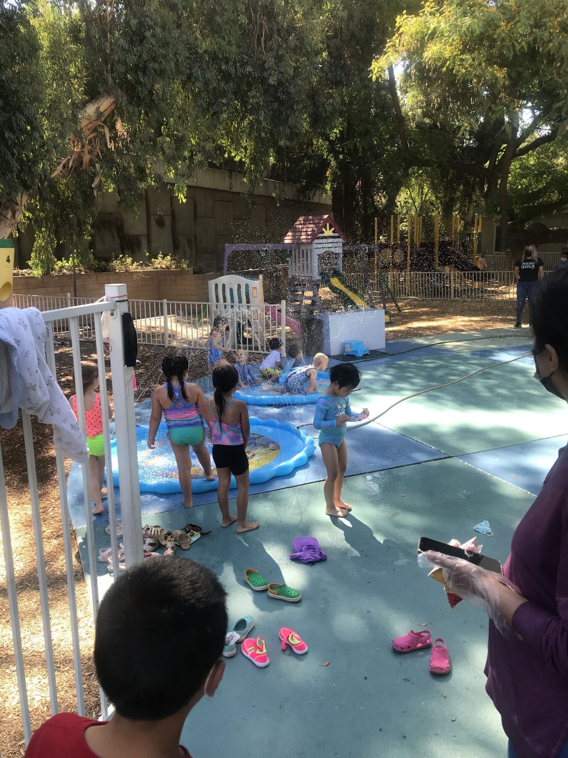 A group of children are playing in a pool in a park.