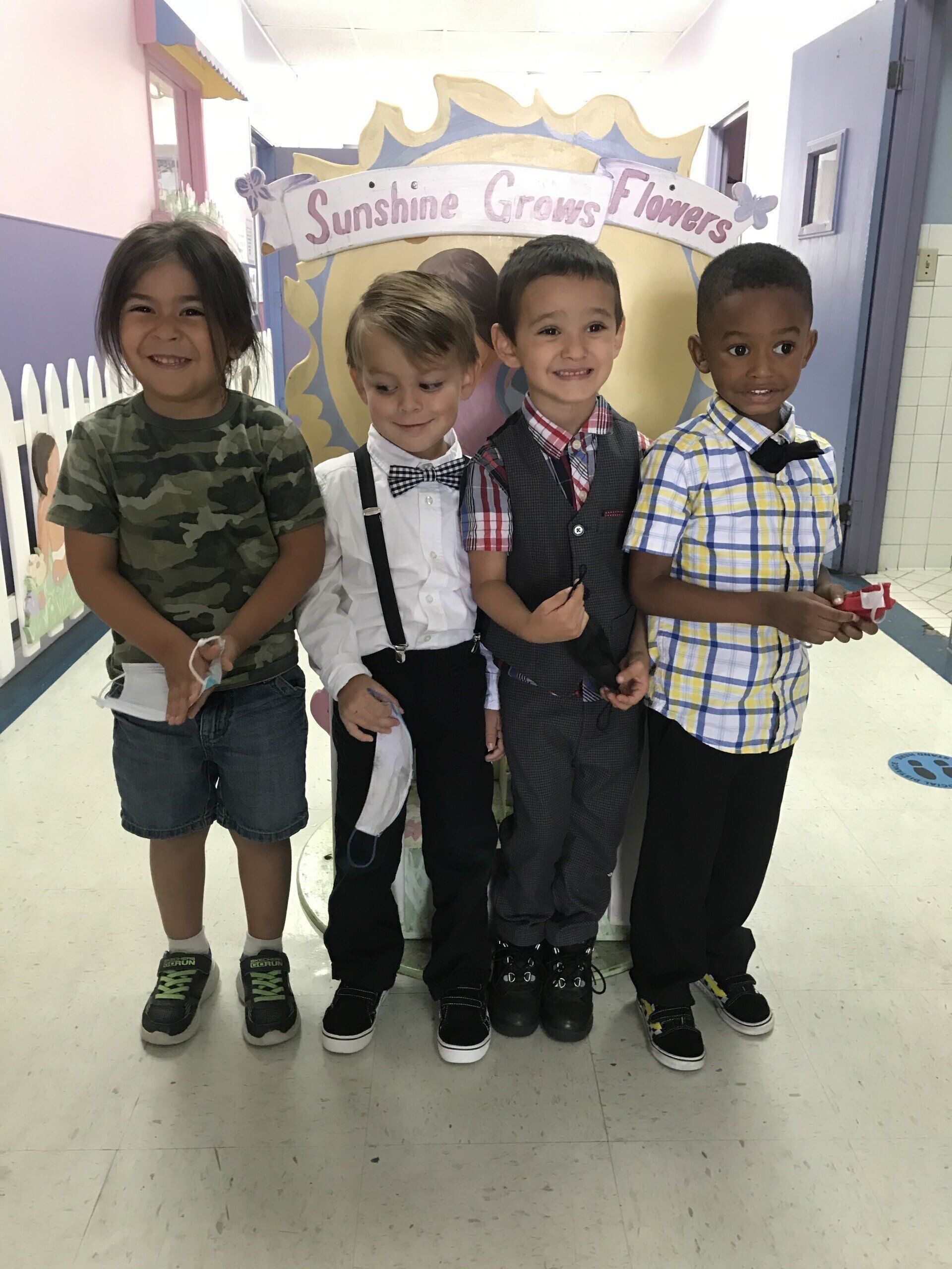 A group of young boys are posing for a picture in a hallway.