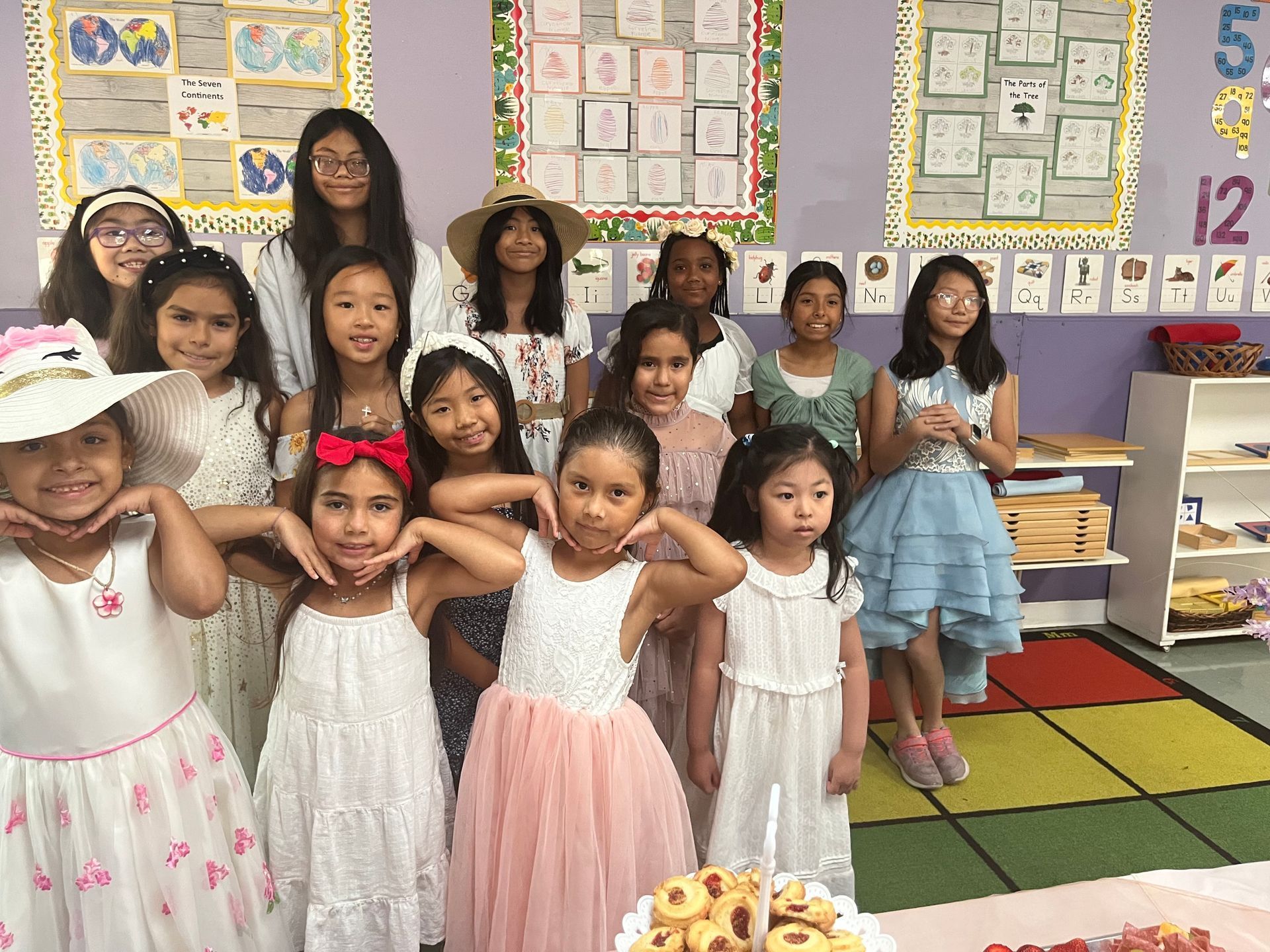 A group of young girls are posing for a picture in a classroom.