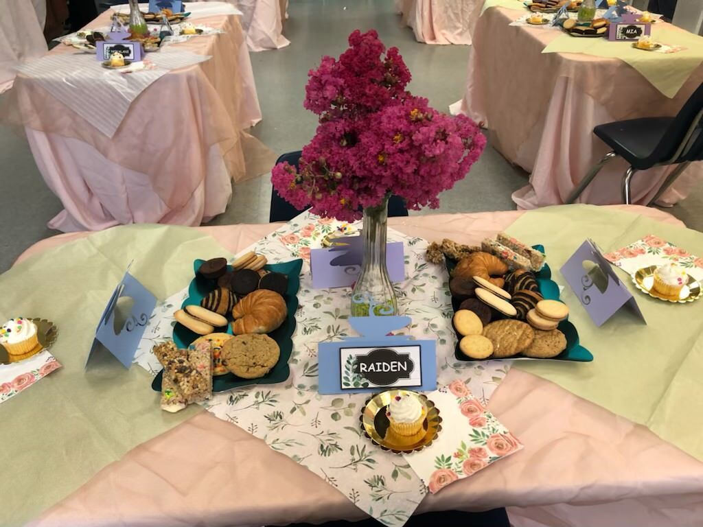 A table with a variety of cookies and flowers on it
