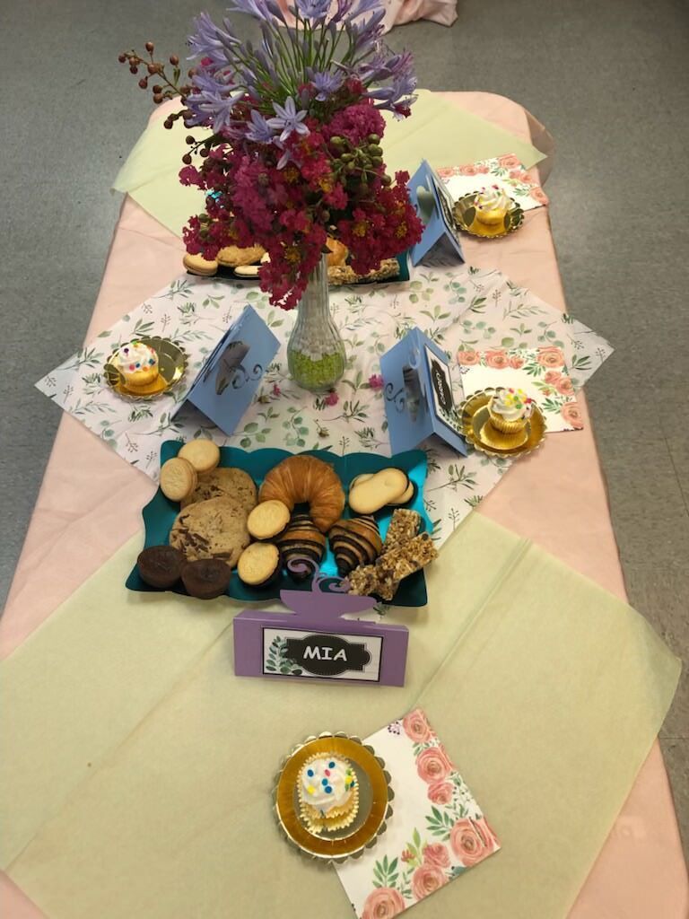 A table with a variety of cookies and flowers on it