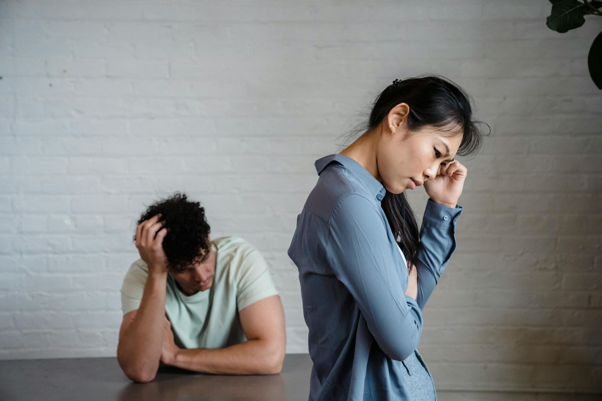 A man and a woman are sitting at a table with their backs to each other.