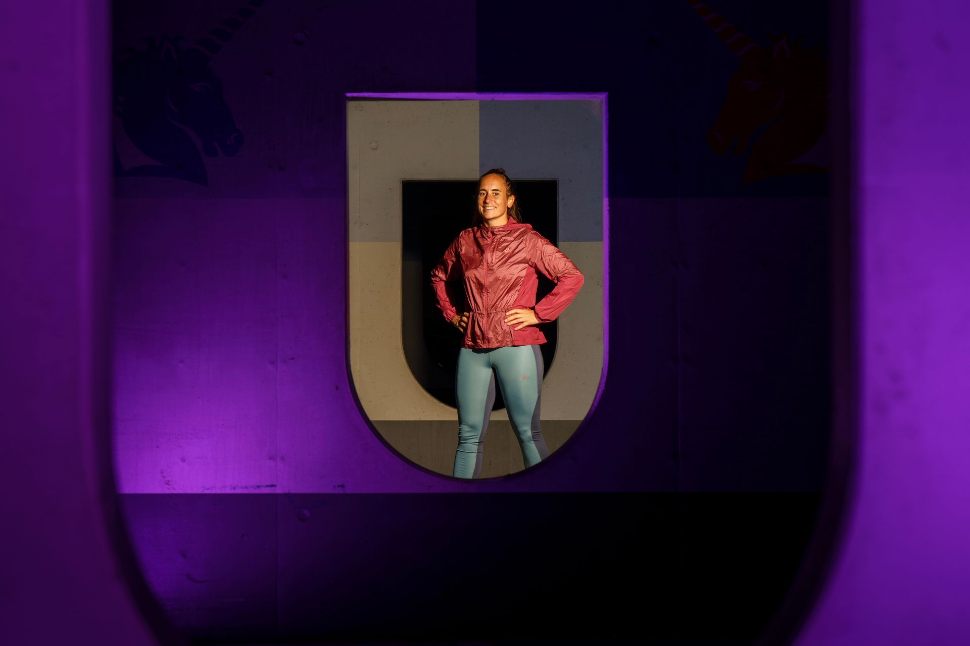 Een vrouw staat voor een paarse muur.