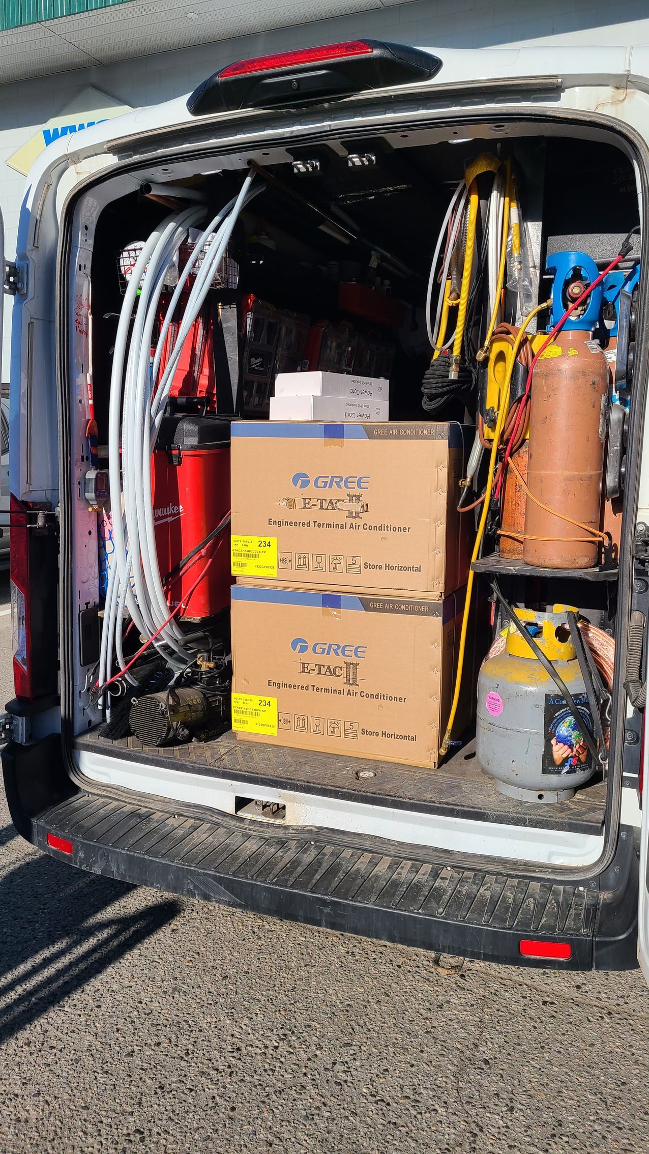 The back of a van is filled with tools and boxes.