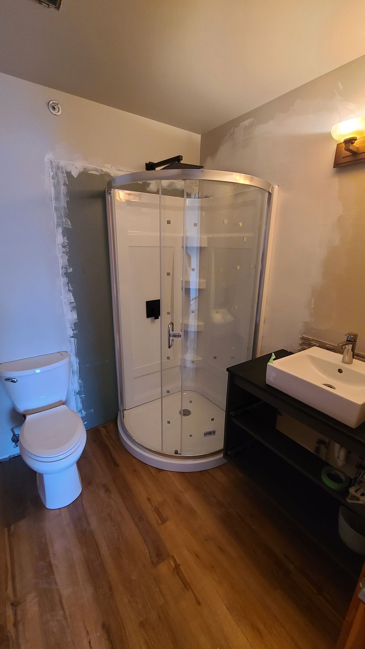 A bathroom with a toilet , sink and shower stall.