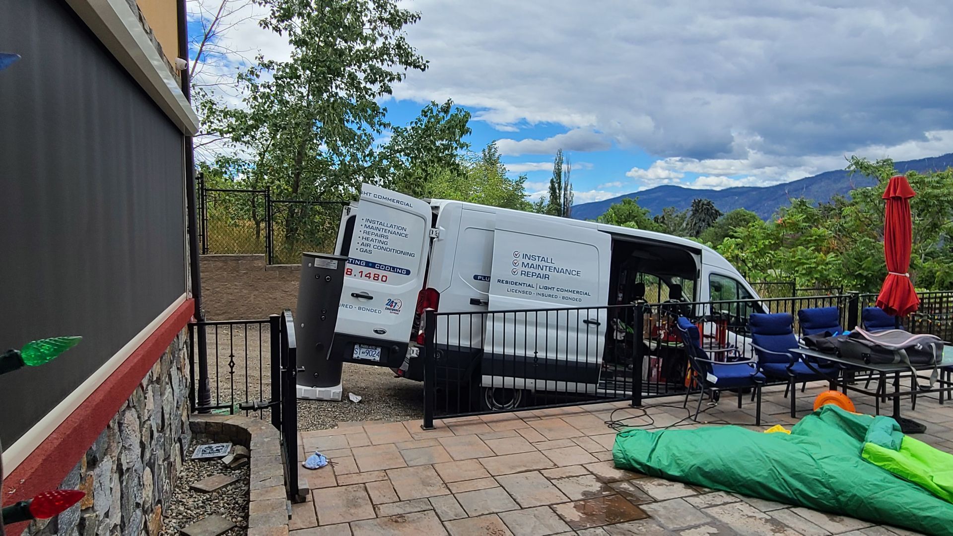 A white van is parked on a patio next to a pool.