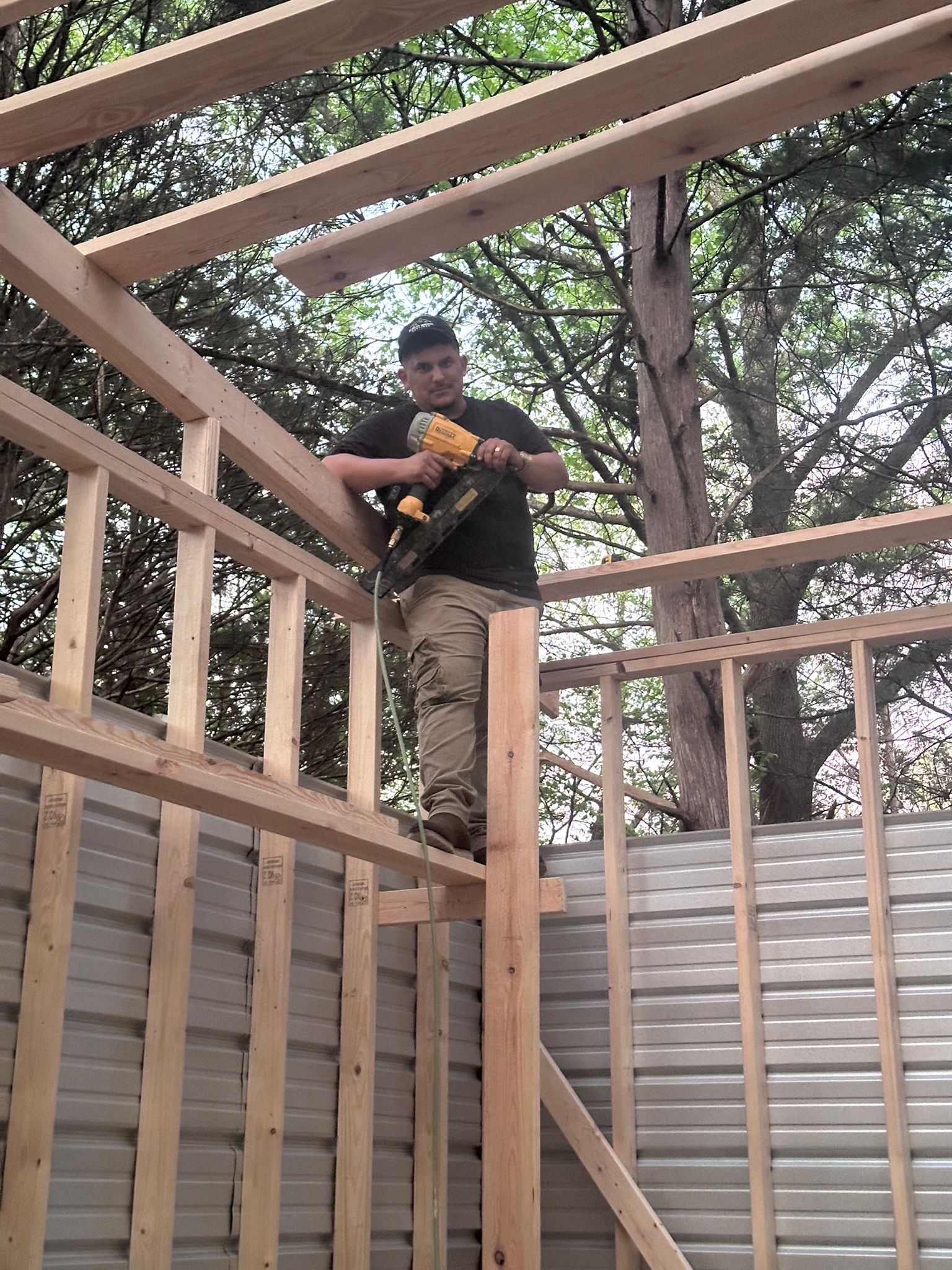 A man is holding a hammer and a level in his hands.