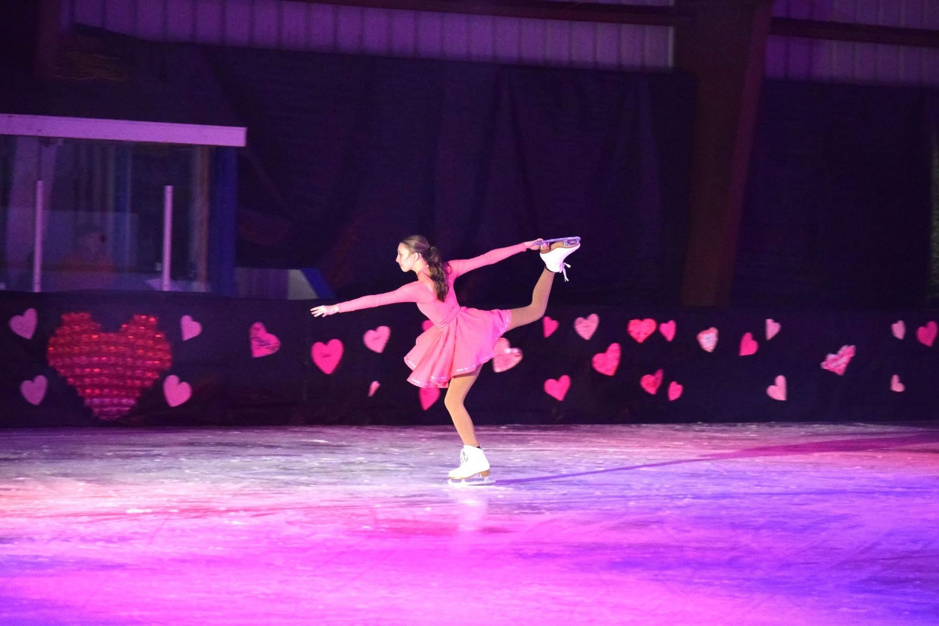 Baseball glove with ball on green grass, with blurred baseballs in the background.