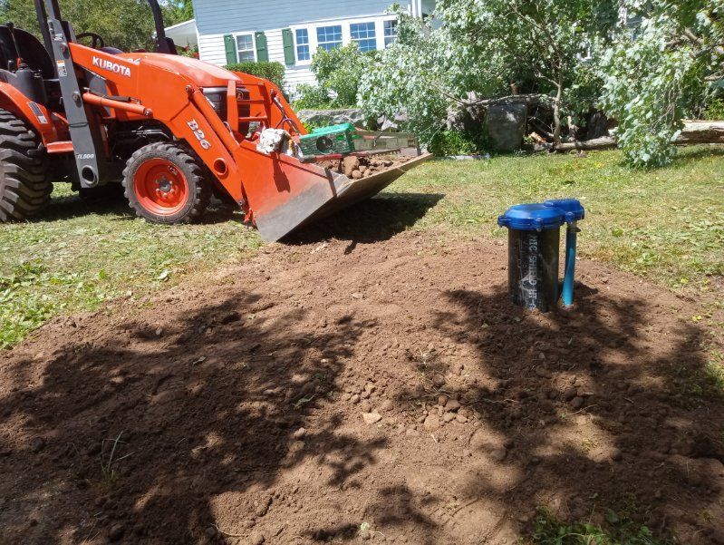 A tractor is digging a hole in the ground in a yard.