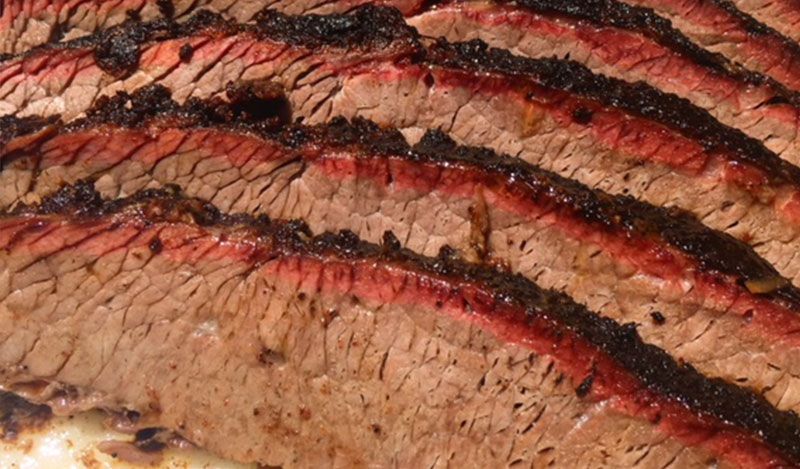 A close up of a slice of beef brisket on a plate.