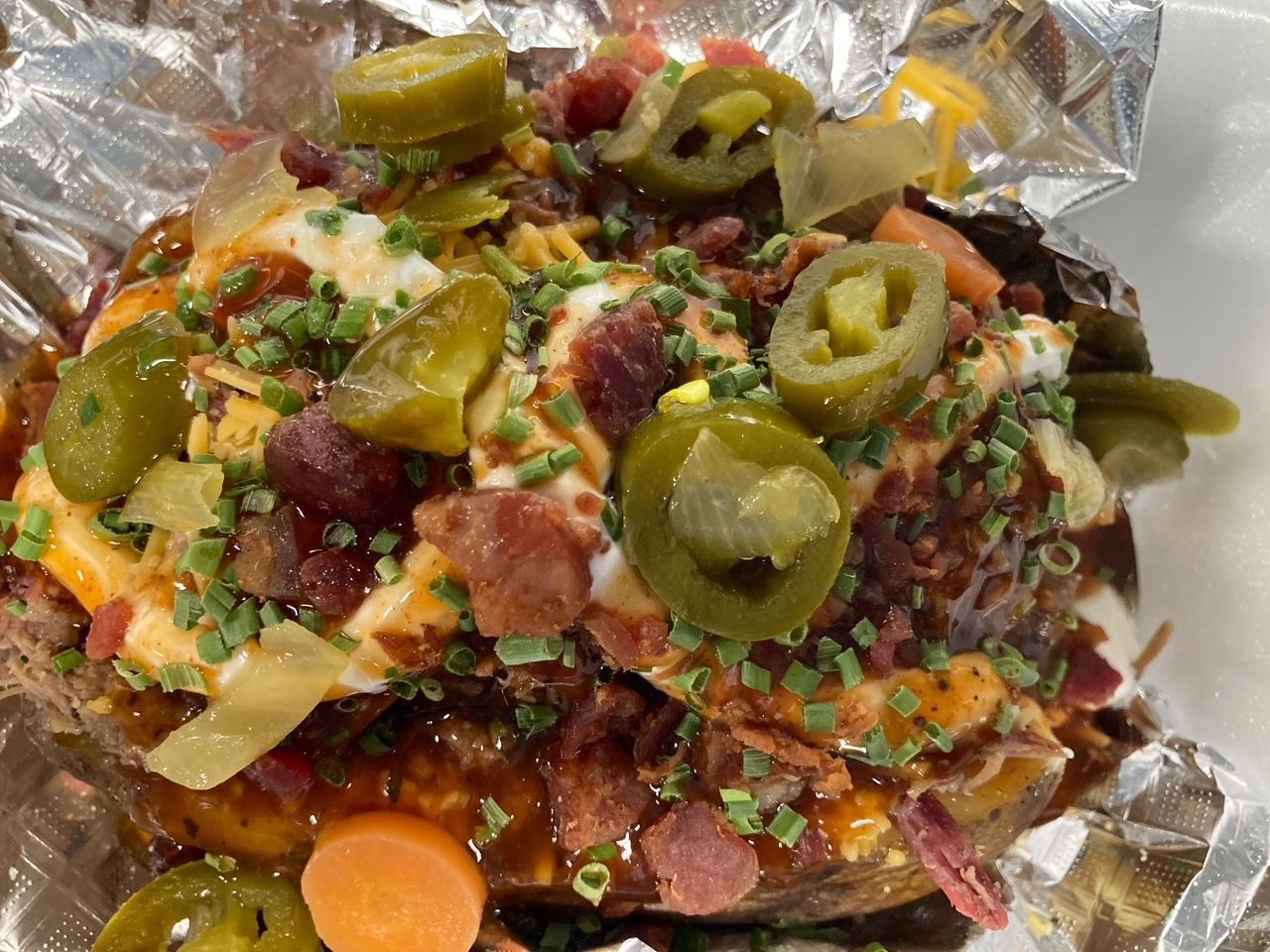 A baked potato with a lot of toppings on it.