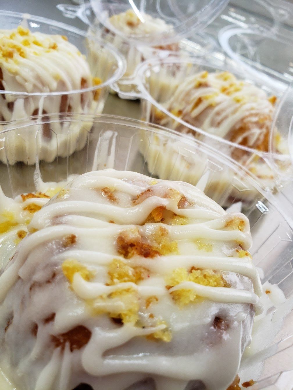 A close up of a cinnamon roll in a plastic container.