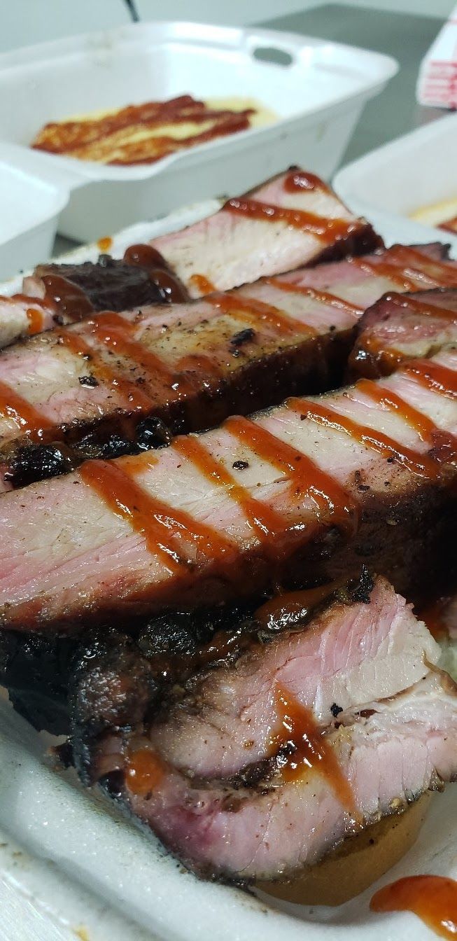 A close up of a tray of meat with sauce on it.
