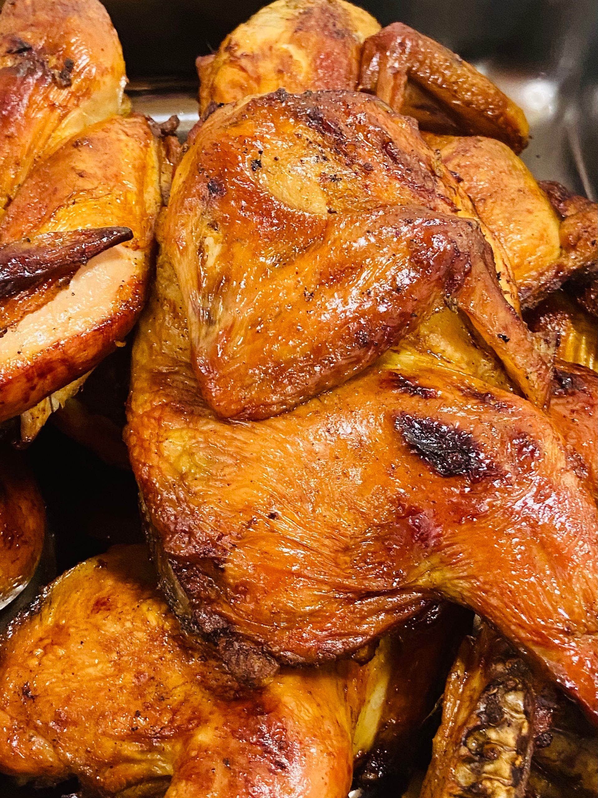 A close up of a pile of grilled chicken wings in a pan.