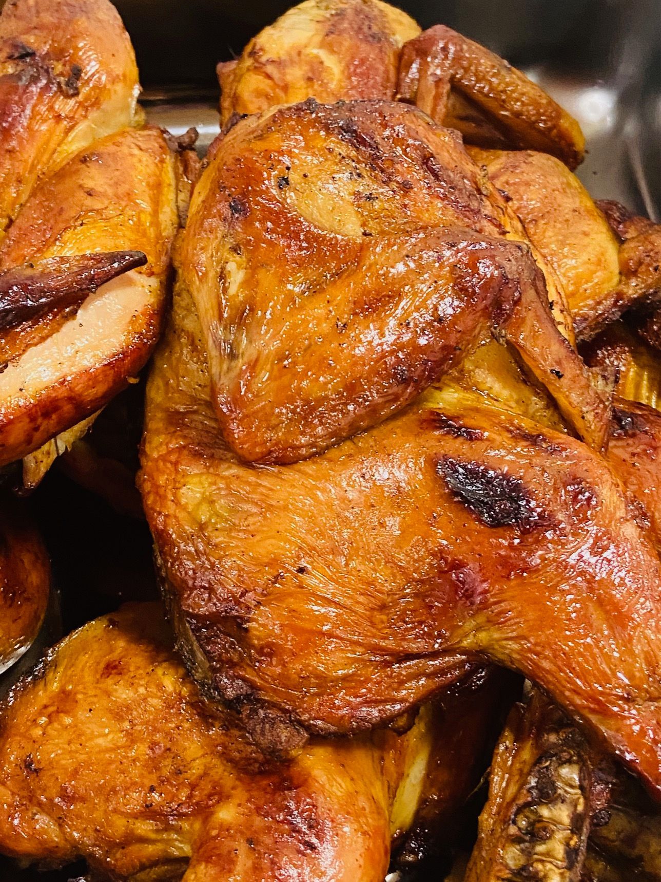 A close up of a pile of grilled chicken wings in a pan.