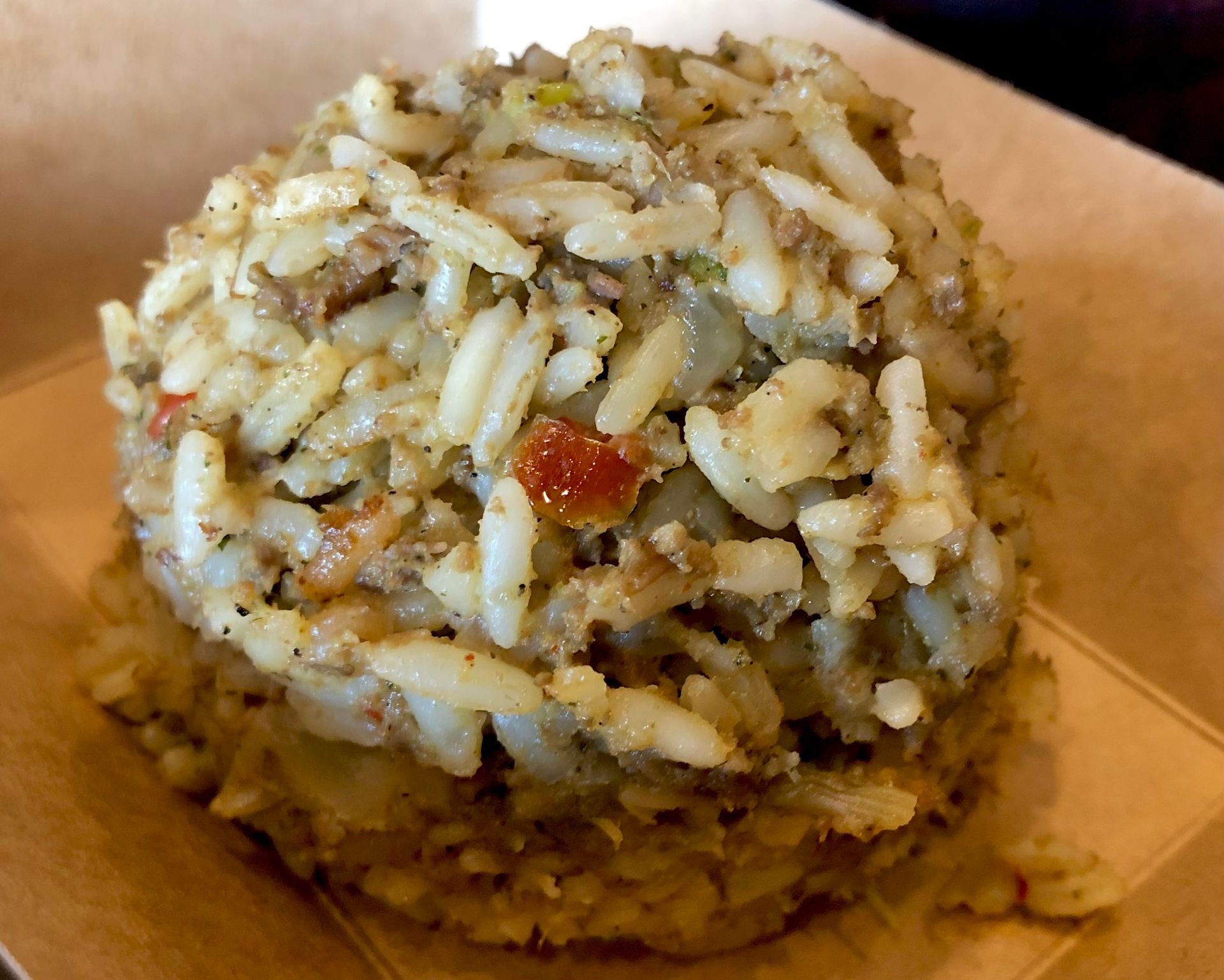 A close up of a rice ball with meat and vegetables