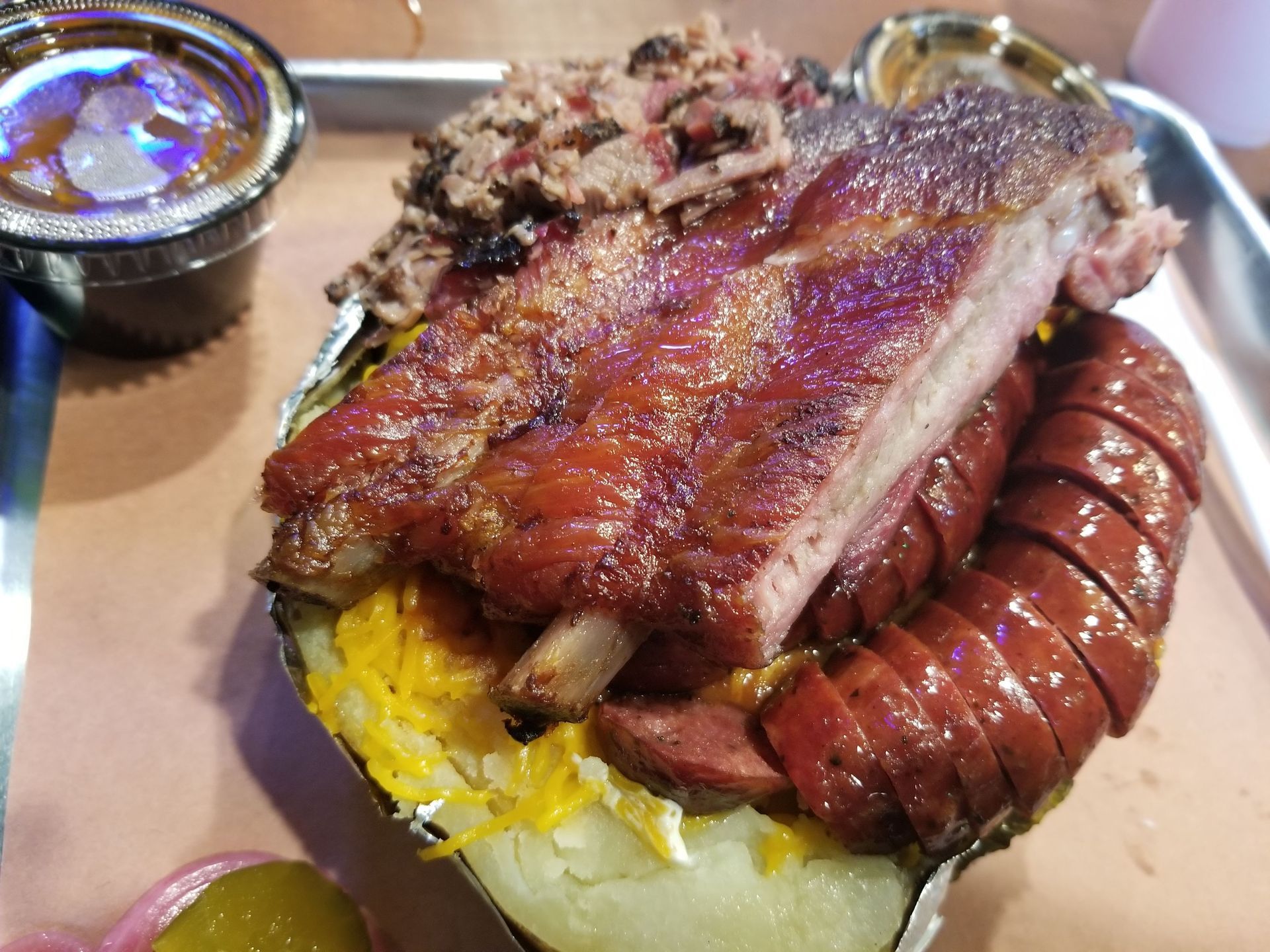 A baked potato filled with ribs and sausage