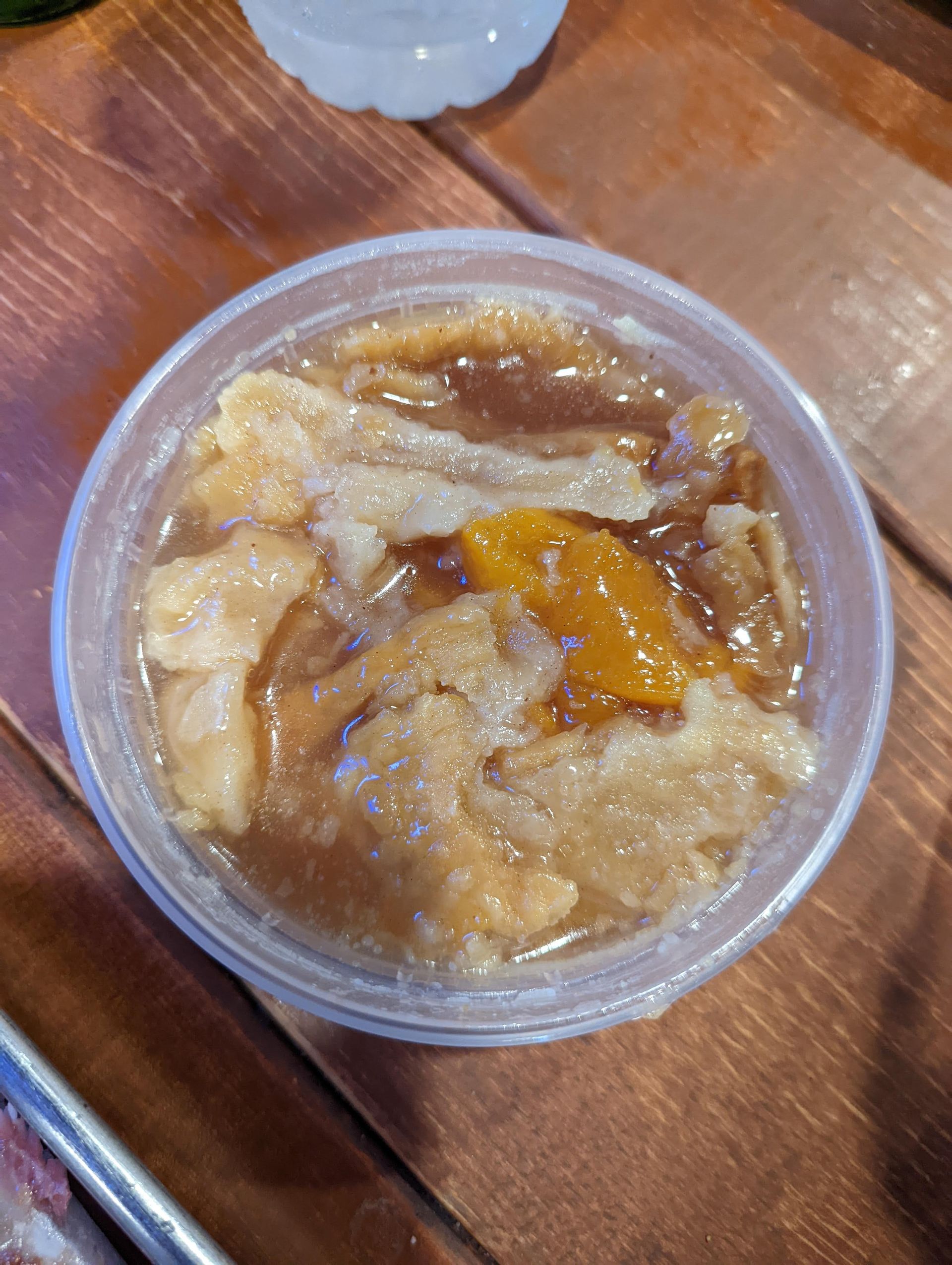 A close up of a bowl of food on a wooden table.