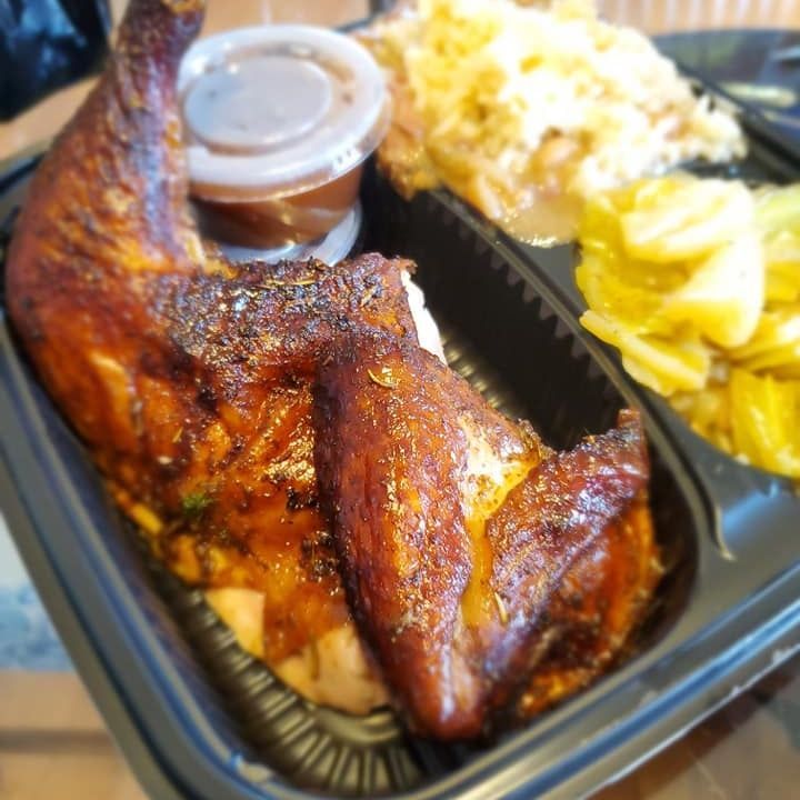 A black plastic container filled with chicken and rice