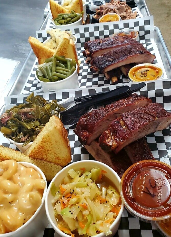 A tray of food with ribs , green beans , macaroni and cheese , coleslaw , and toast.