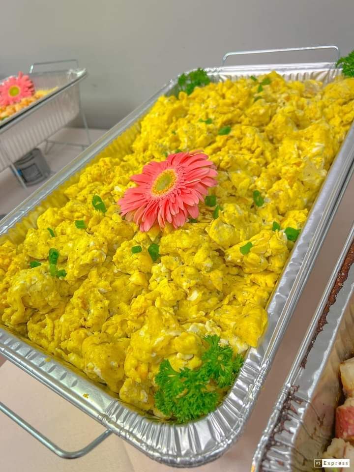 A tray of food with a pink flower on top of it.