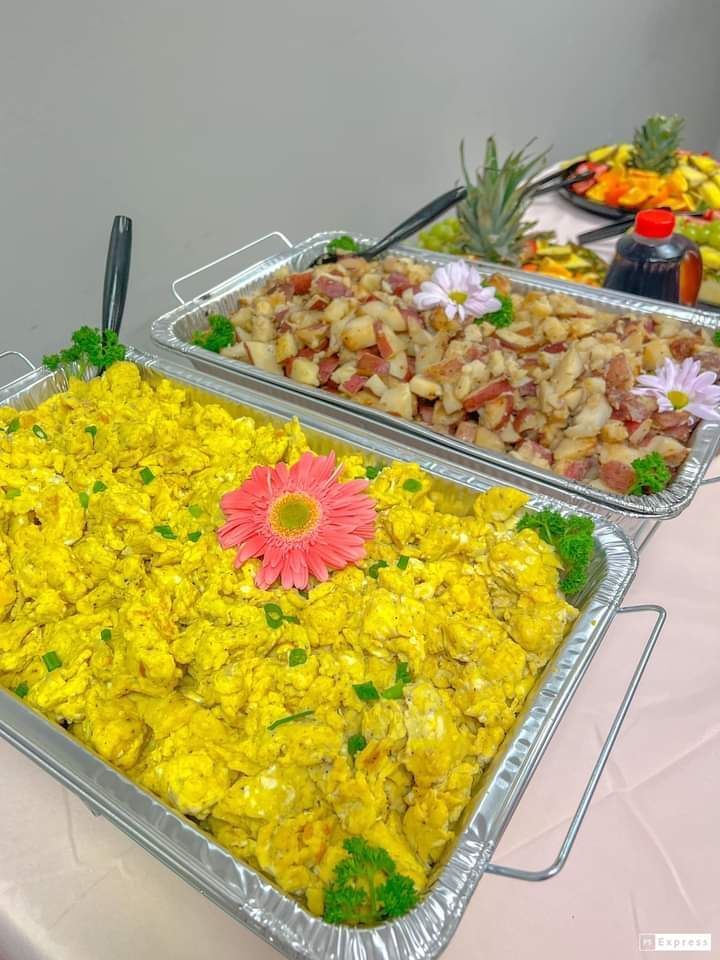 A tray of food with a flower on top of it on a table.
