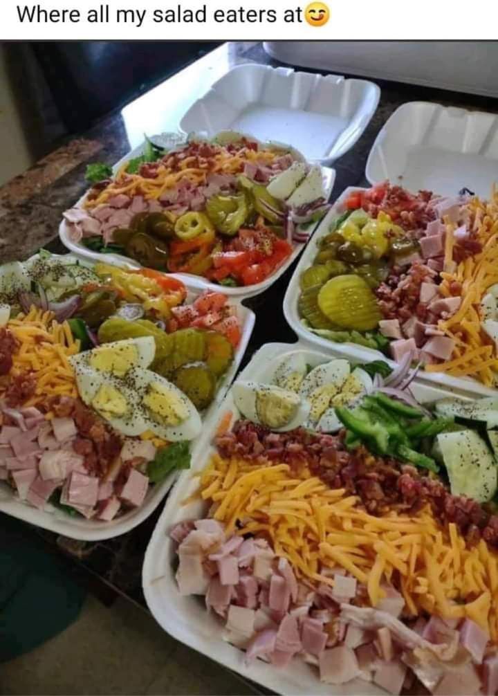 There are many different types of salads on the table.