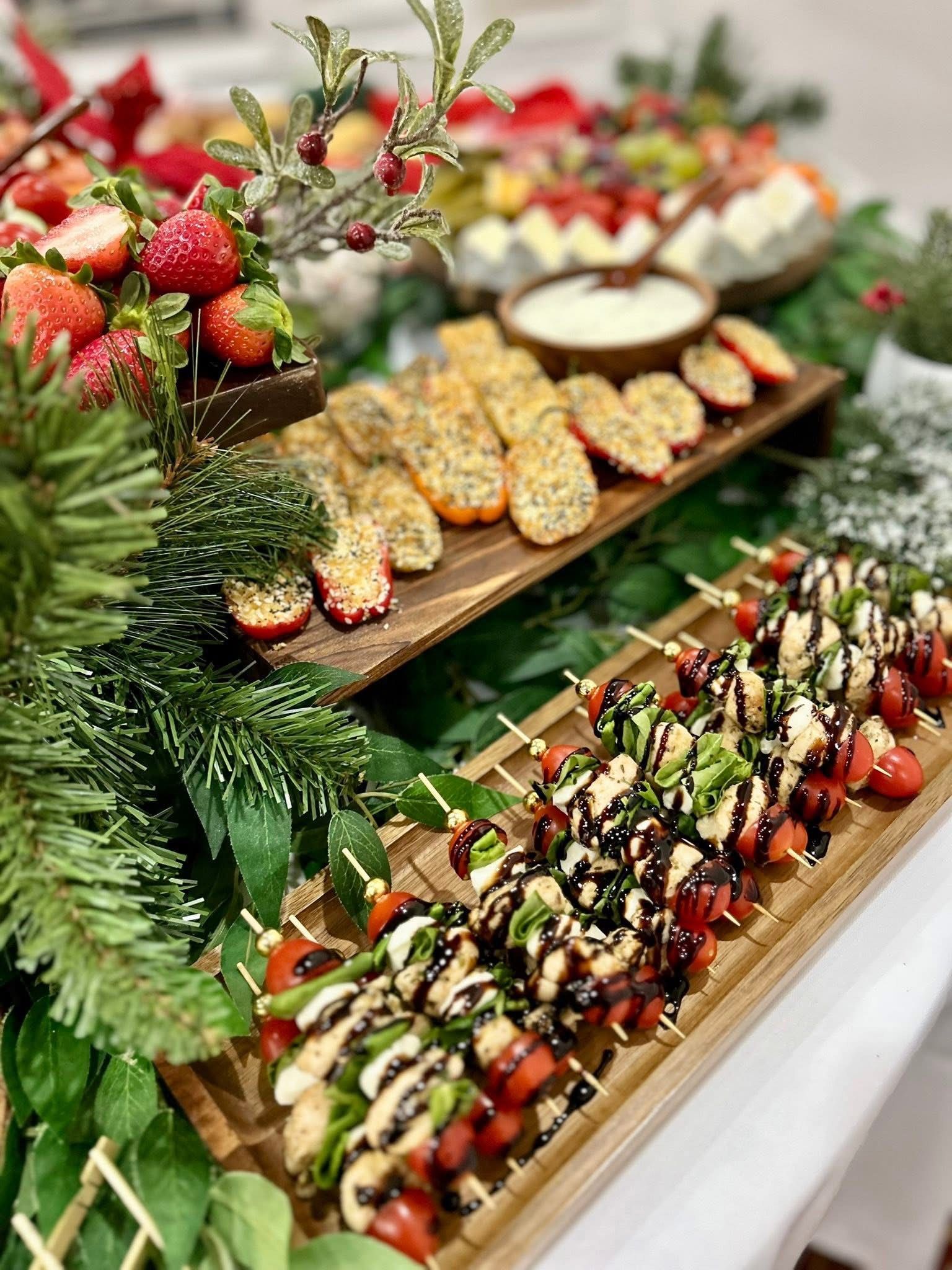 Roasted mini bell peppers stuffed with cheese and seeds on a wooden tray, surrounded by greenery.