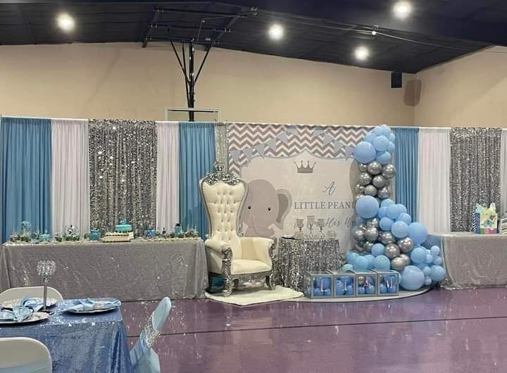 A room filled with tables and chairs and balloons for a baby shower.