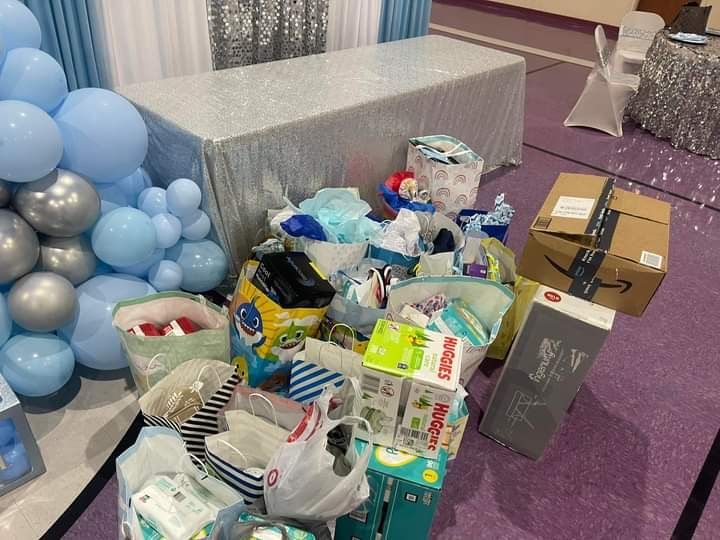 A pile of diapers and boxes are sitting on the floor in a room.