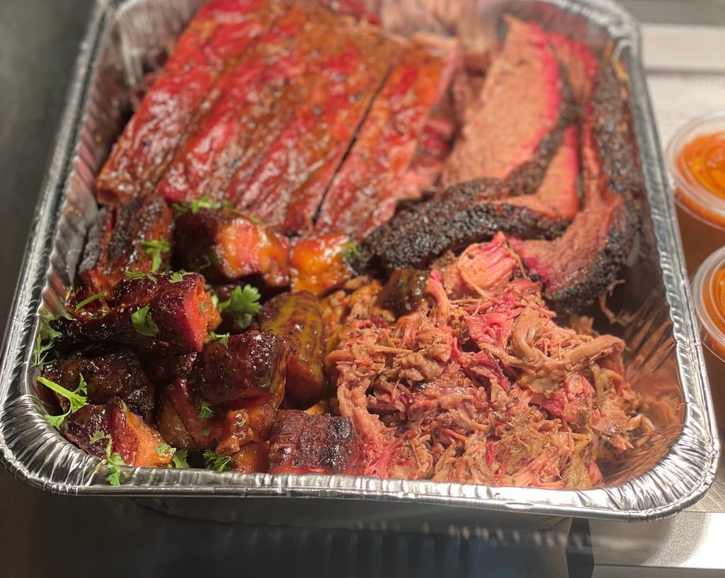 Aluminum foil tray filled with meat and sauce on a table.
