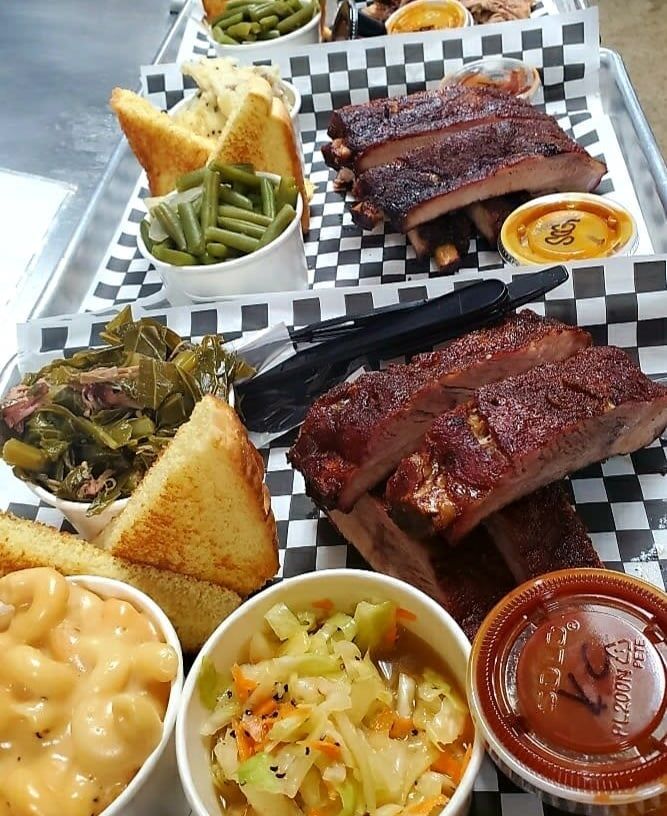 A tray of food including ribs green beans and macaroni and cheese