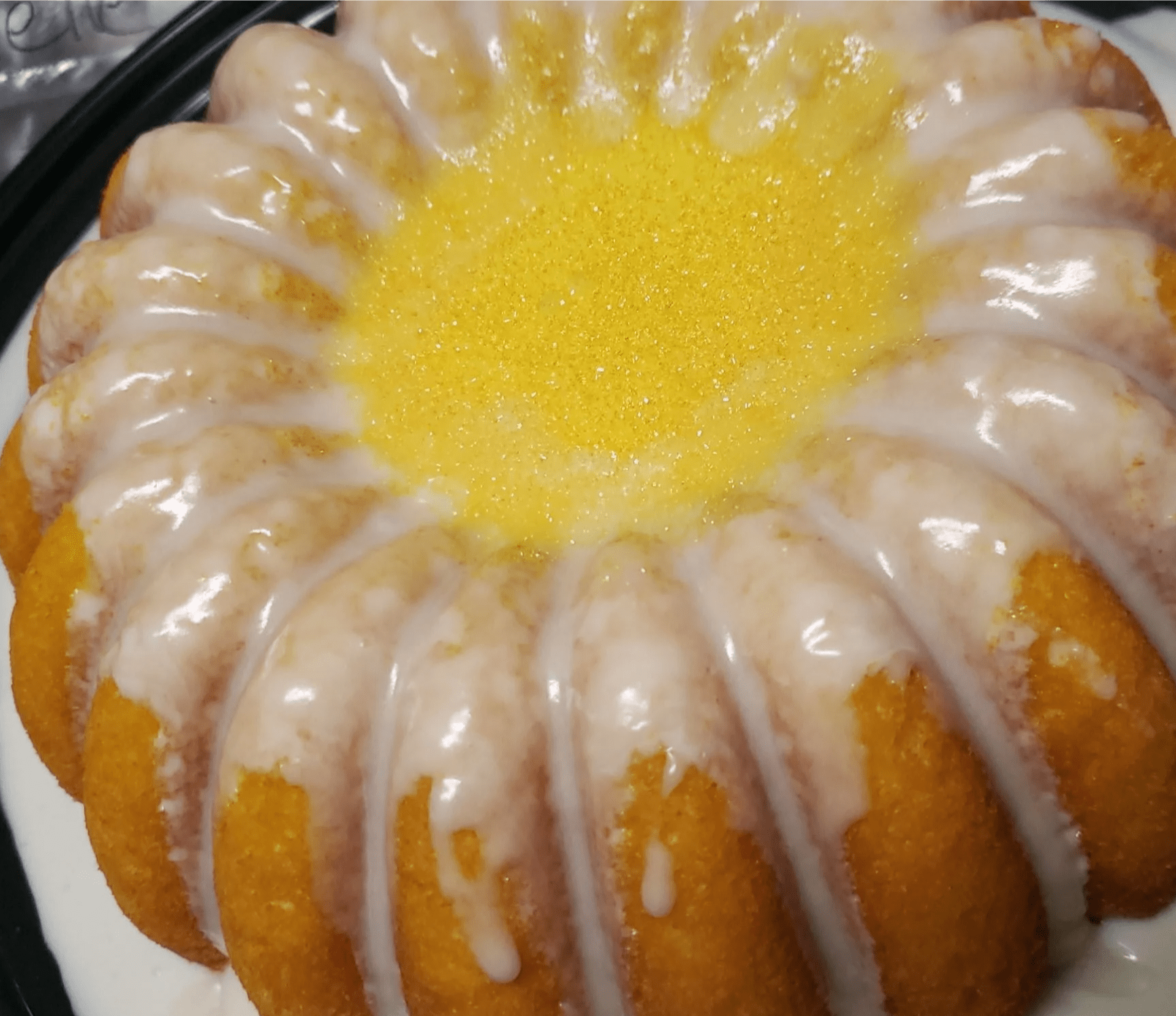 A bundt cake with lemon icing and sprinkles on top