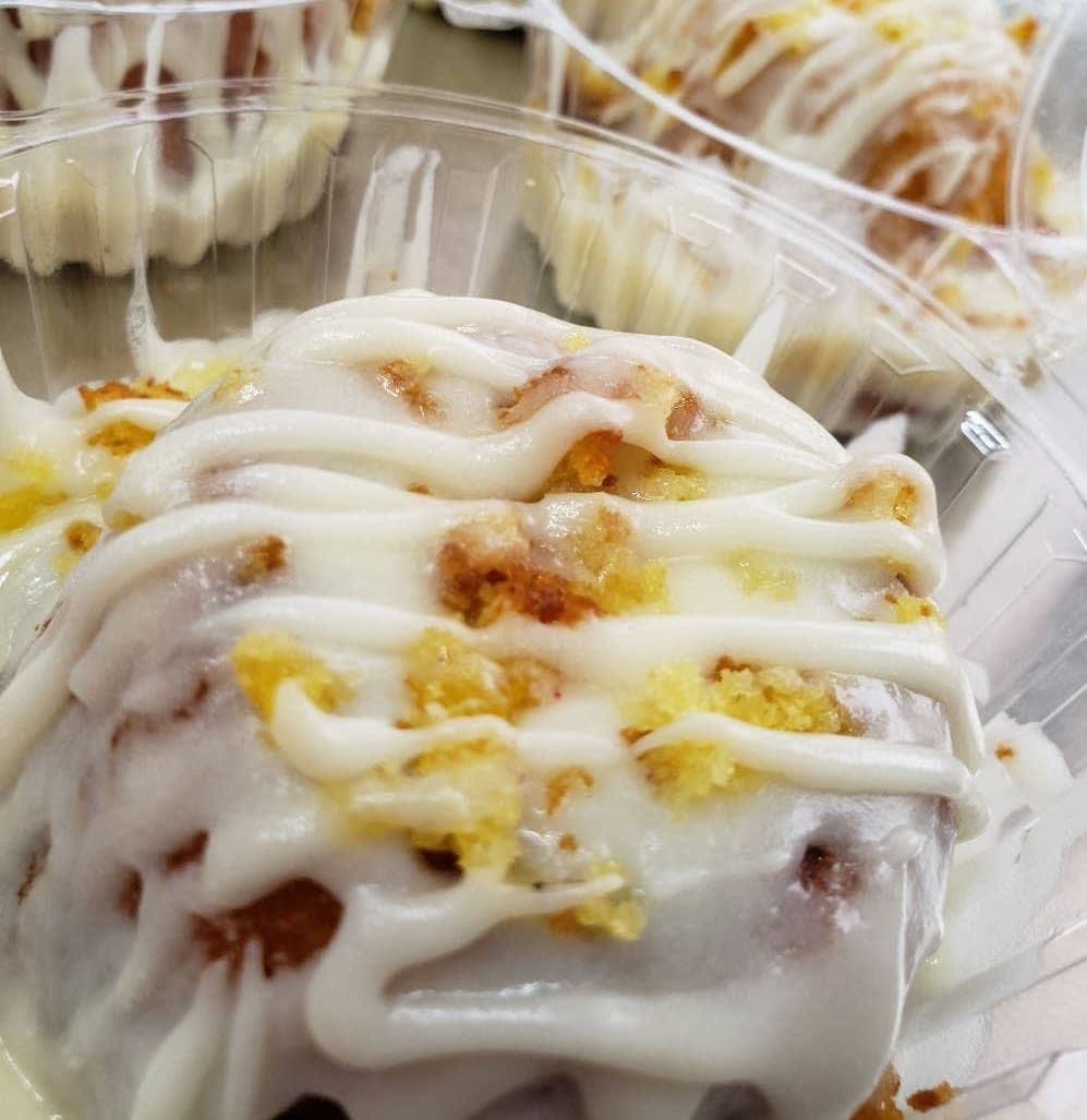 A close up of a glazed donut in a plastic container