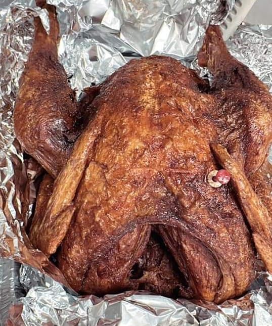 A roasted turkey is wrapped in tin foil