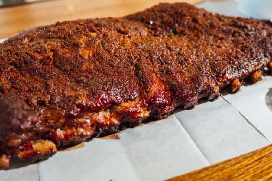 A large piece of meat is sitting on top of a wooden table.