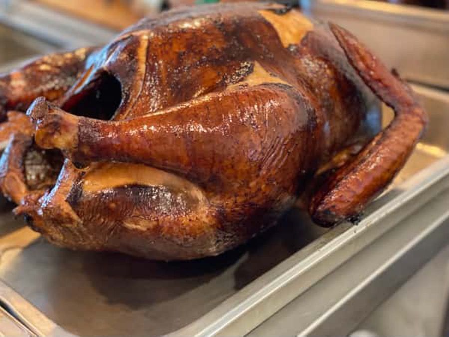 A roasted turkey is sitting on top of a metal tray.