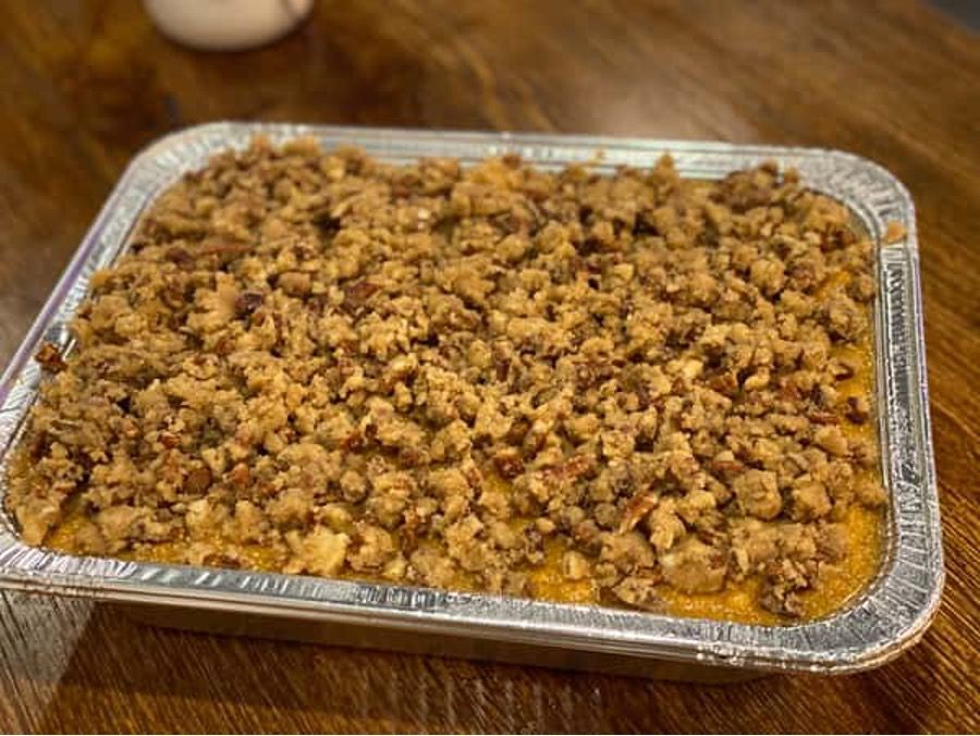 A casserole dish filled with food is sitting on a wooden table.