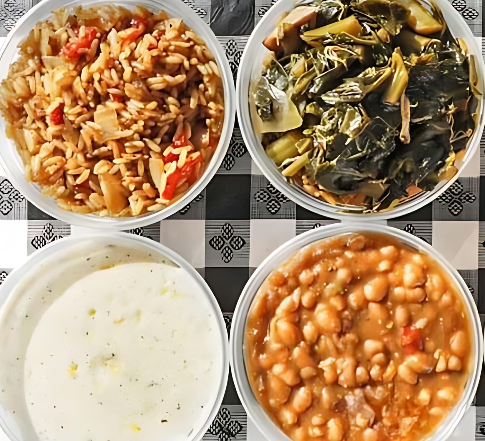 Four bowls of food are on a checkered table cloth