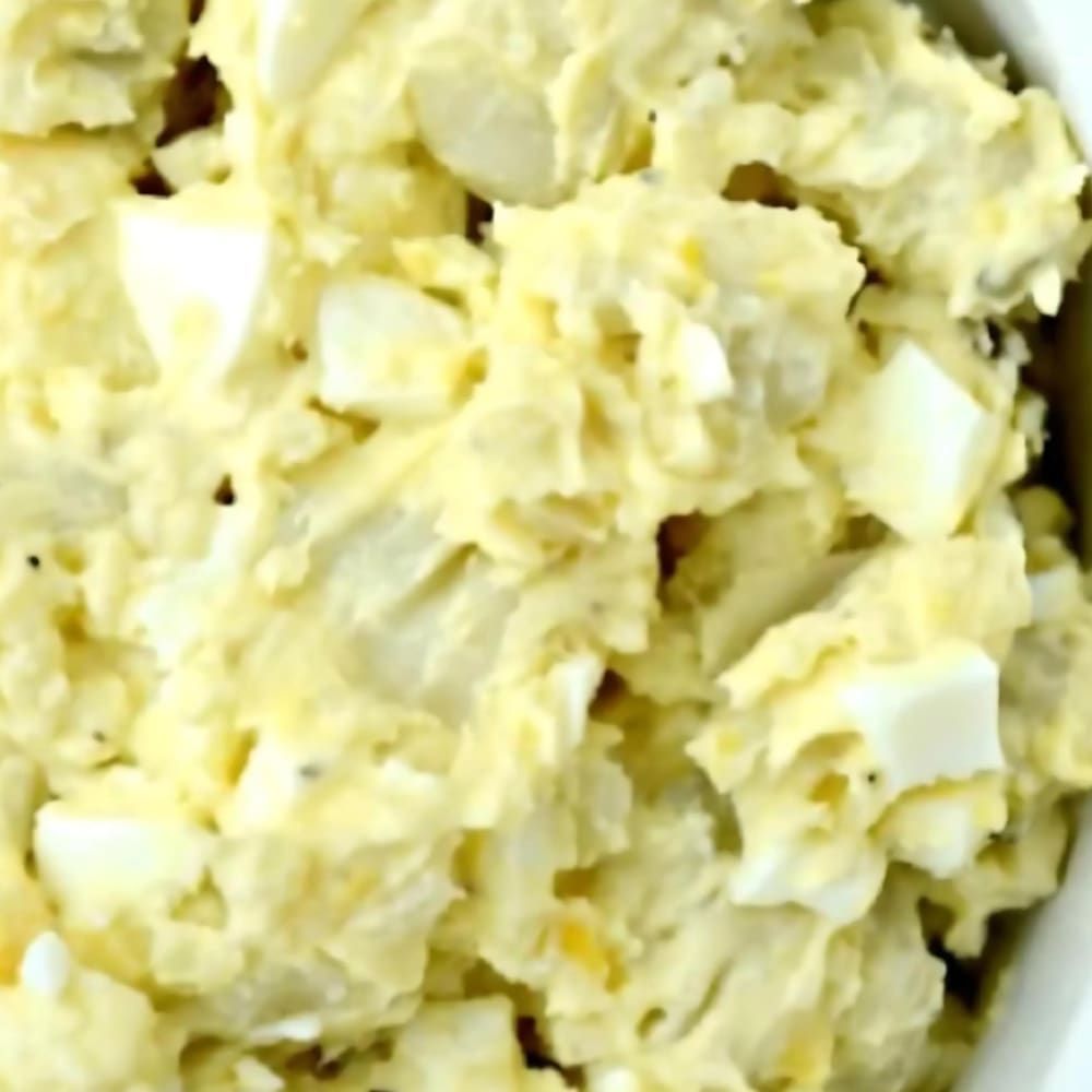 A close up of a bowl of potato salad with eggs
