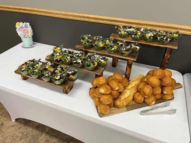 A table with a bunch of food on it and a tong on it.