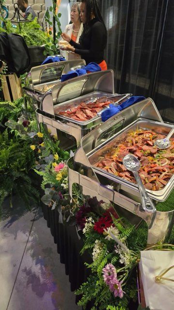 A buffet table filled with lots of food and flowers.