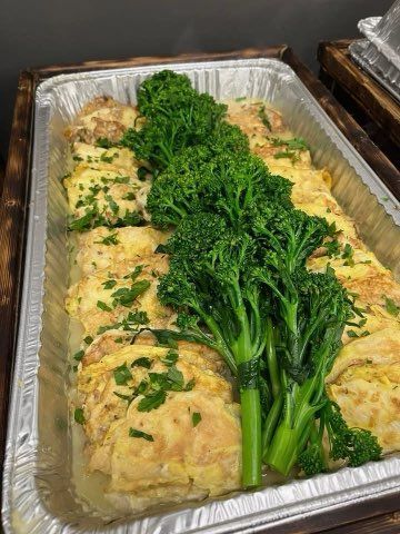 There is a tray of food with broccoli on top of it.