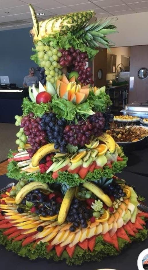 A tower of fruits and vegetables on a table