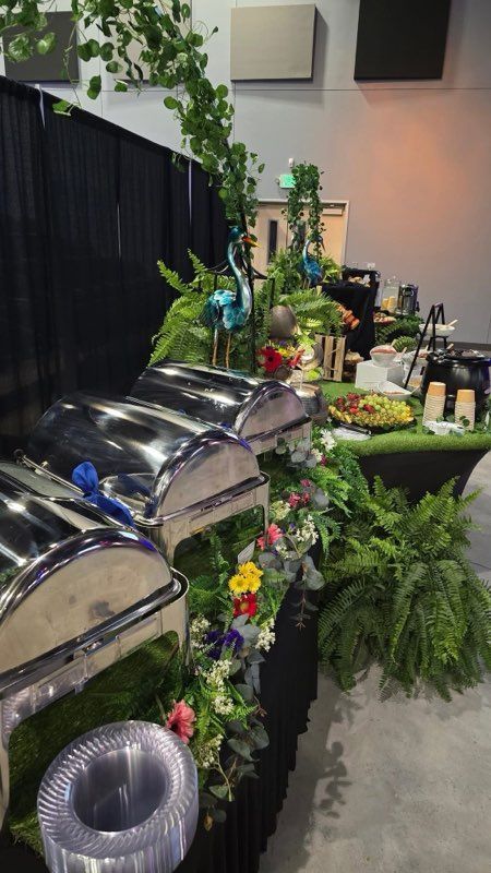 A buffet table with flowers and plants on it.