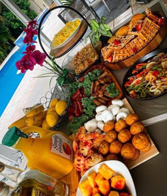 A table topped with a variety of food including a bottle of orange juice